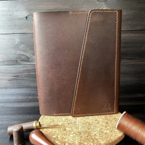 Кожаная обложка с узором для блокнота формата А5 на белом фоне.