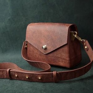 Выкройка маленькой кожаной женской сумочки на белом фоне.