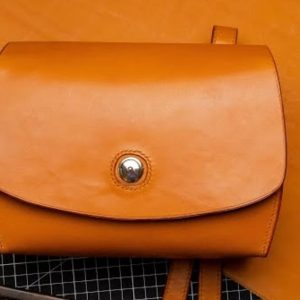 Выкройка кожаного женского клатча на белом фоне.