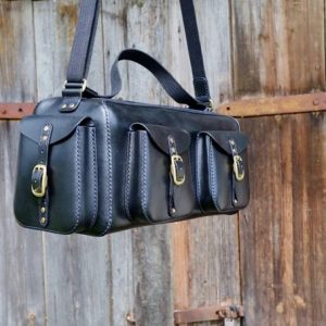 Выкройка кожаной дорожной сумки с карманами на белом фоне.