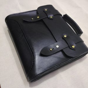 Выкройка кожаного портфеля с пуговицами на белом фоне.