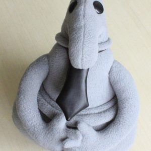 Выкройка маленькой мягкой игрушки в форме персонажа с грустным выражением.