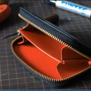 Маленький кожаный кошелек с узором и молнией.