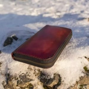 Длинный кожаный кошелек с узором и молнией.